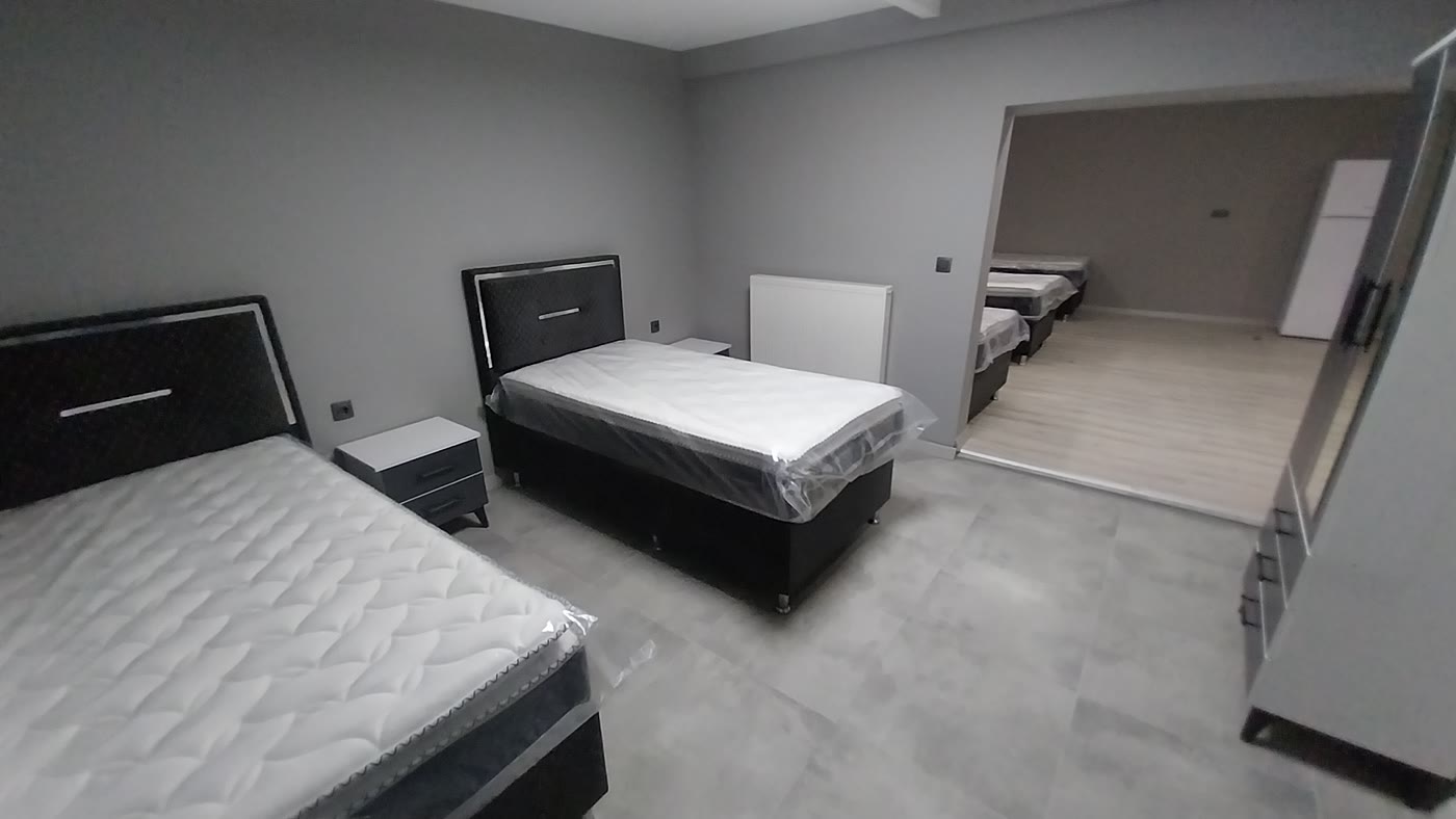 Öğrenci odası — yatak, komodin ve doğal ışık alan pencere